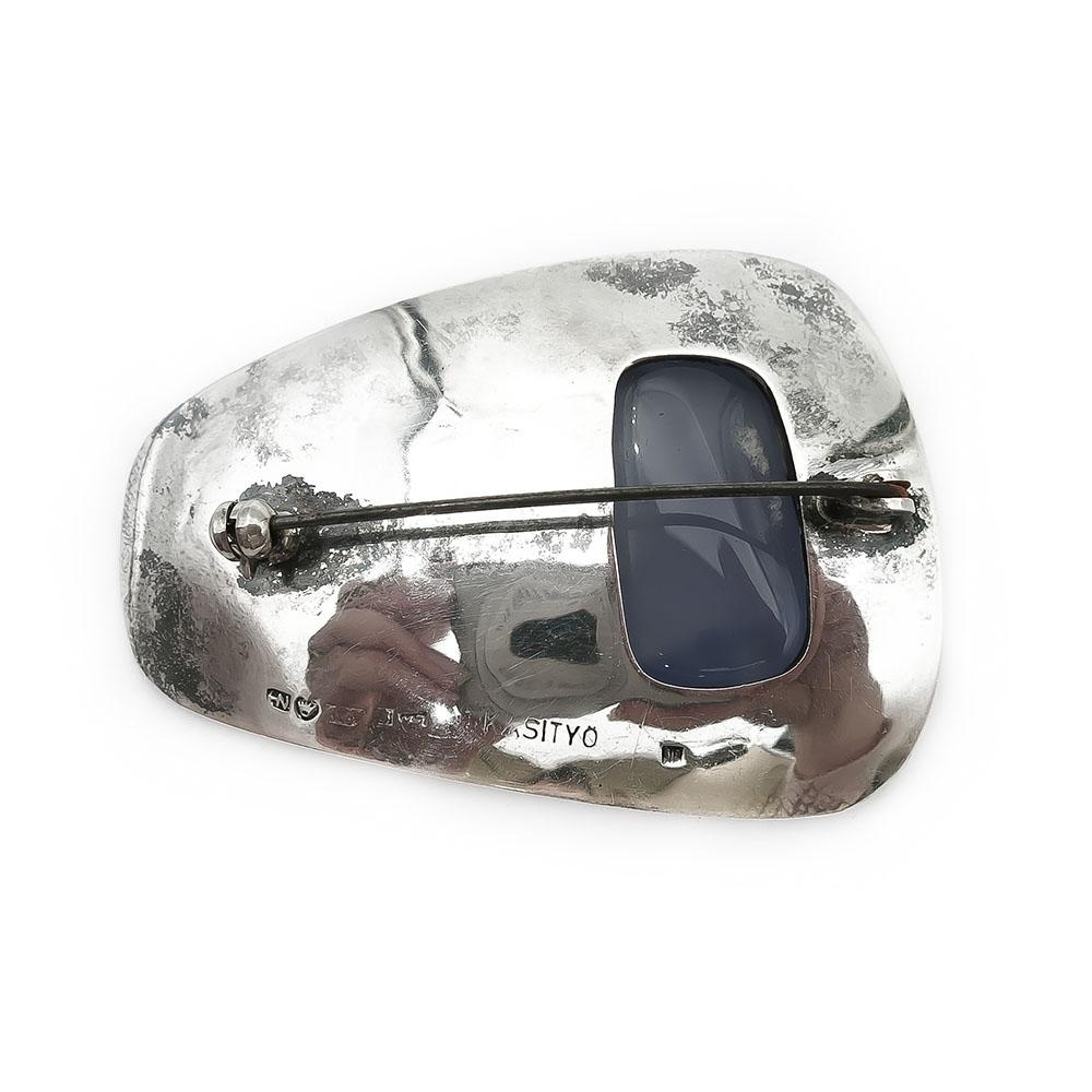 Rintaneula lilalla kivellä, Käsityö v.-63 #1